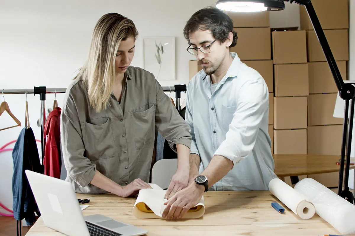 Two colleagues packing customer orders together at a work table