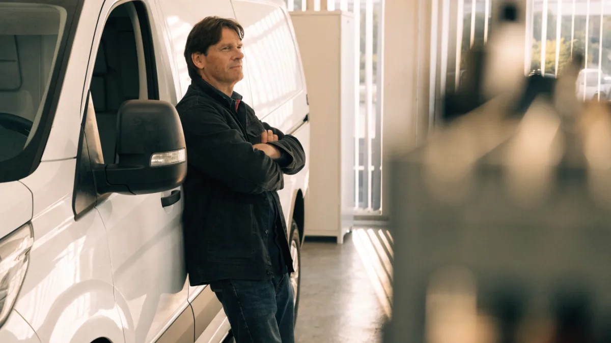 Business owner standing beside a new commercial delivery van